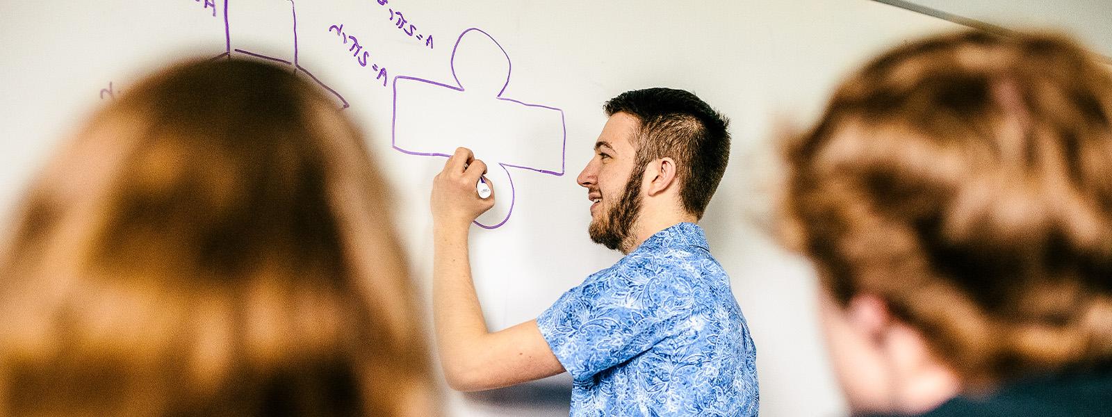 math professor giving lecture holding diagram as example